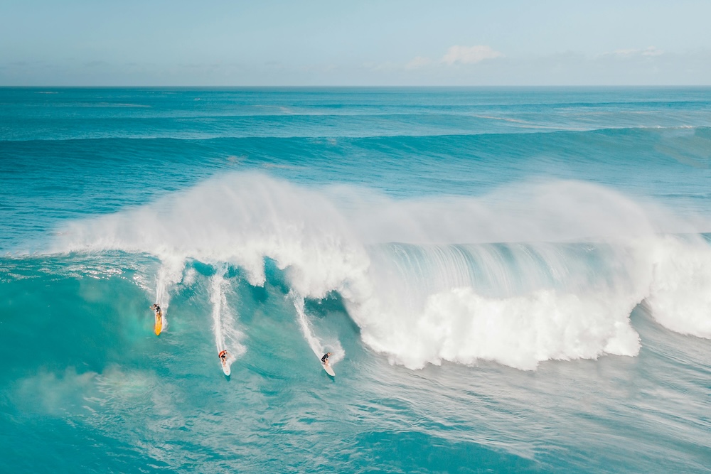 three surfers on a big wave in Hawaii three surfers on a big wave in Hawaii